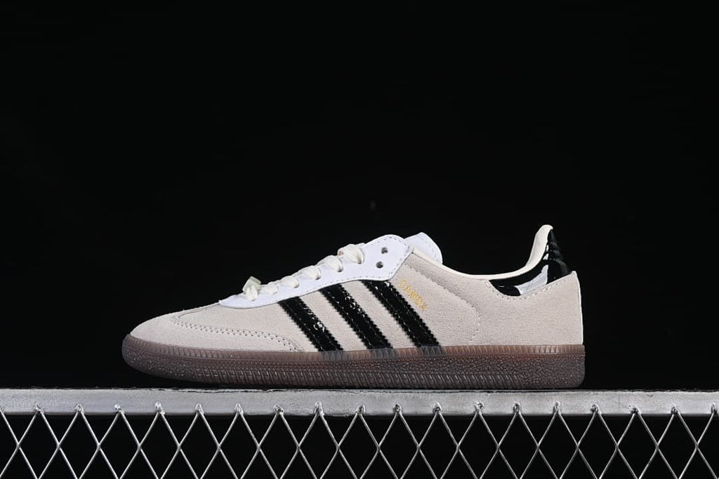 Side view of beige and black adidas Samba OG sneakers with a brown outsole