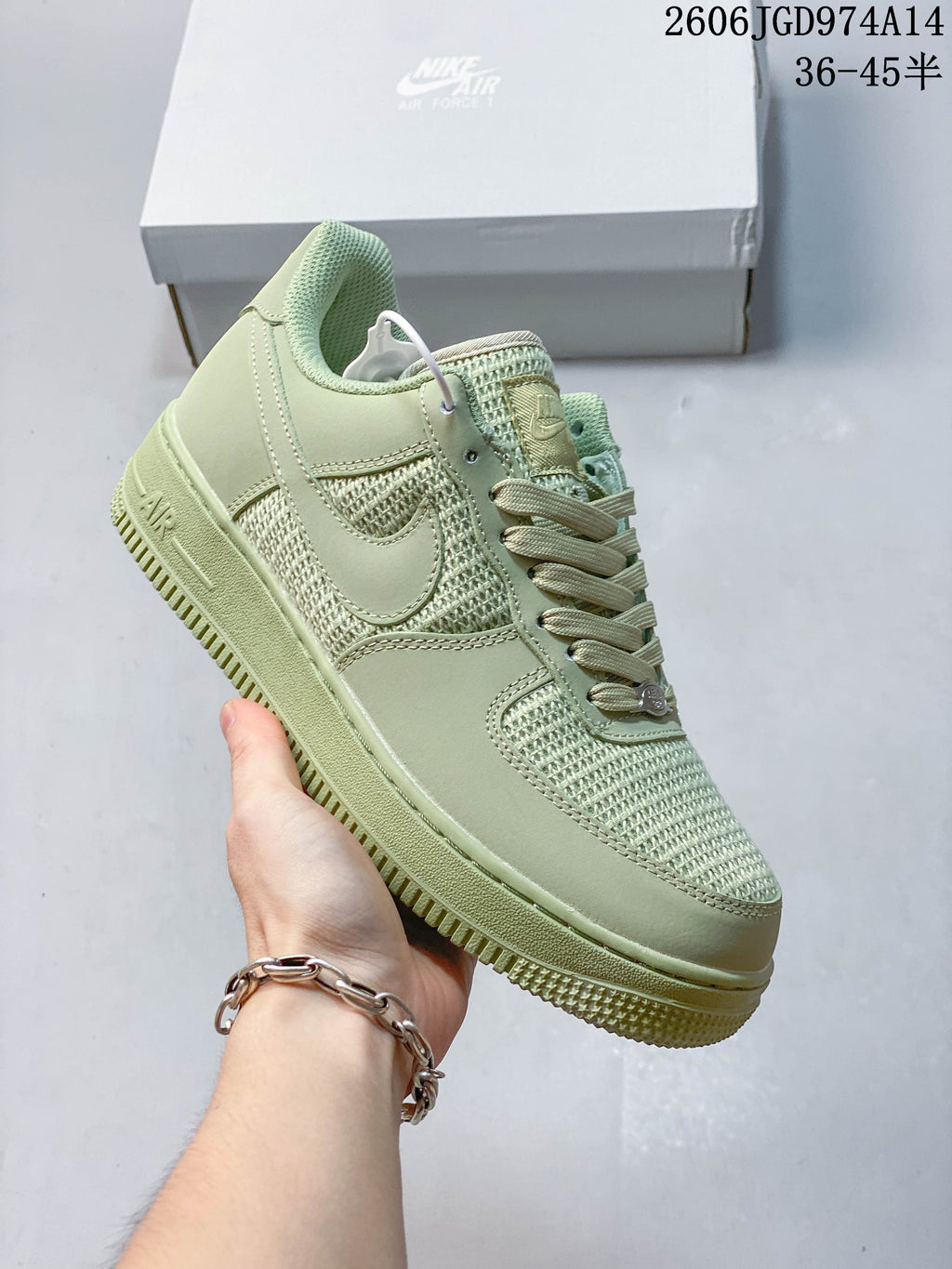 Angled side view of a pale green low-top sneaker with tonal panels and a thick outsole