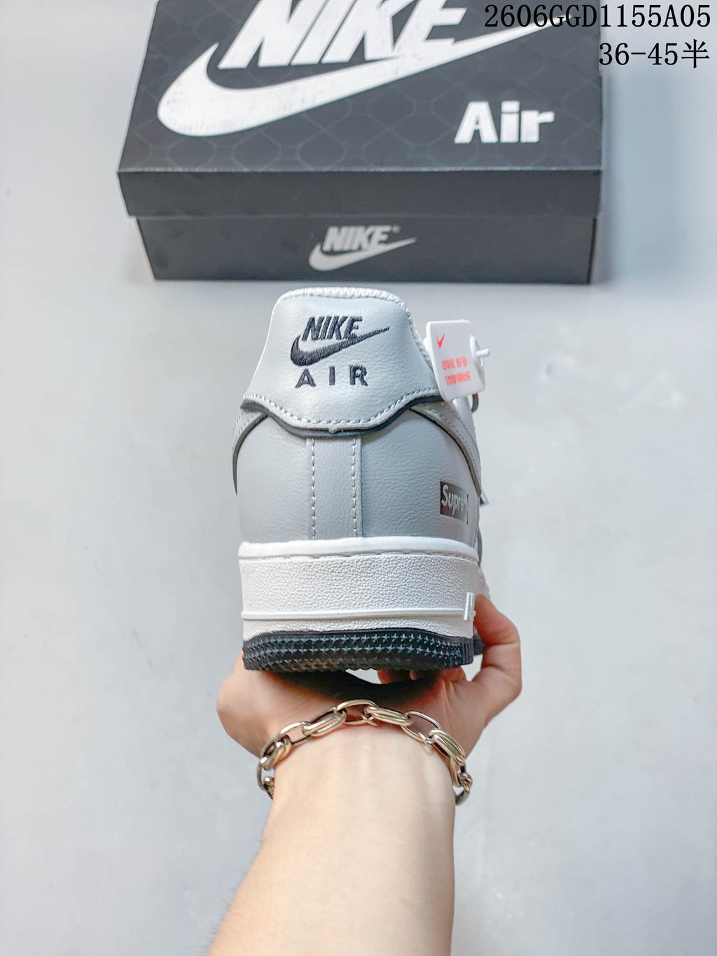 Rear view showing gray heel panels, branded details, white midsole, and dark outsole