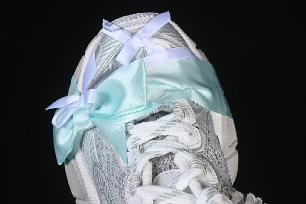 Top view of the sneaker with laces and a pale aqua ribbon detail