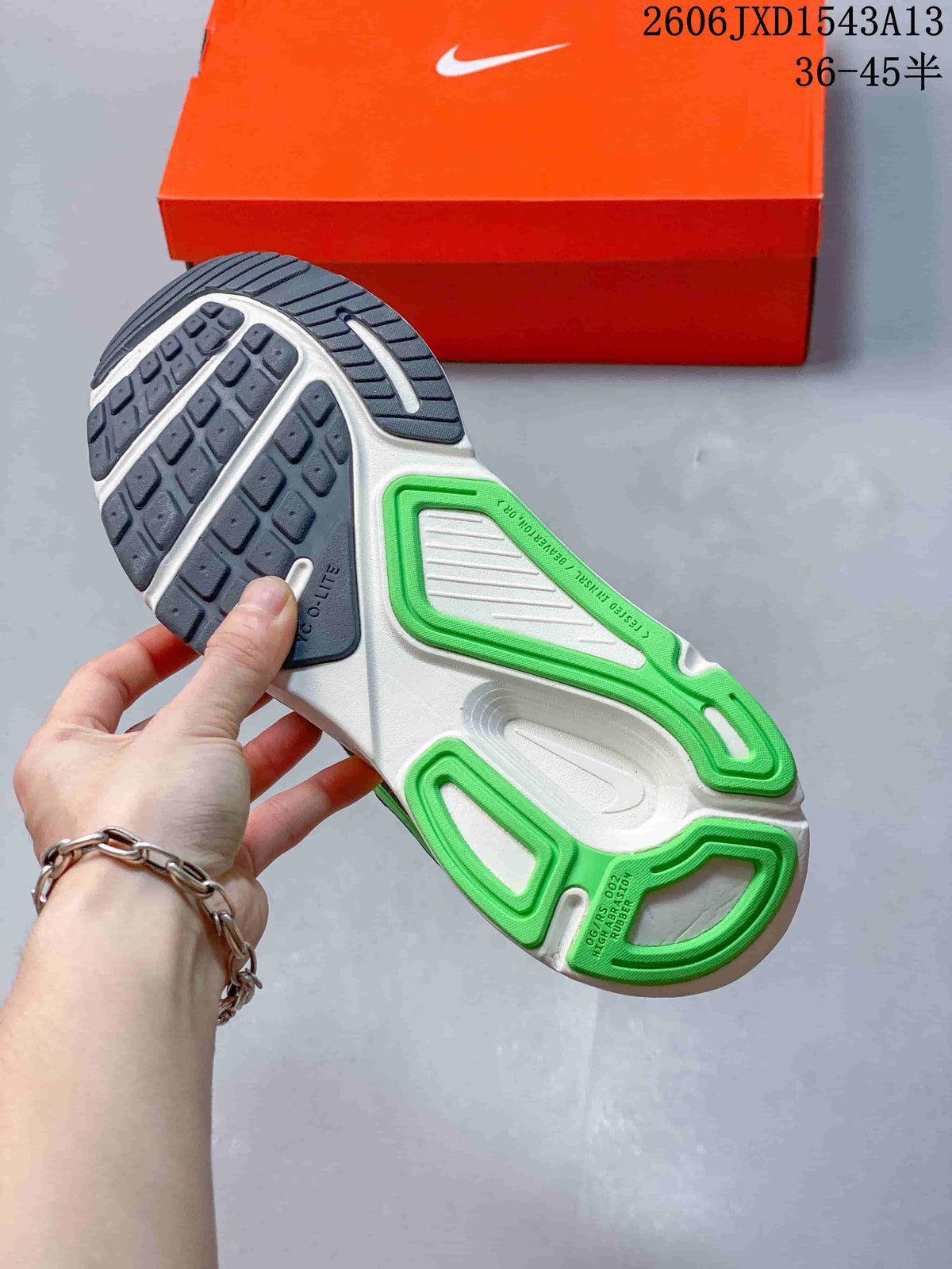 Outsole of a Nike Structure Plus shoe showing dark gray tread and green and white sections.