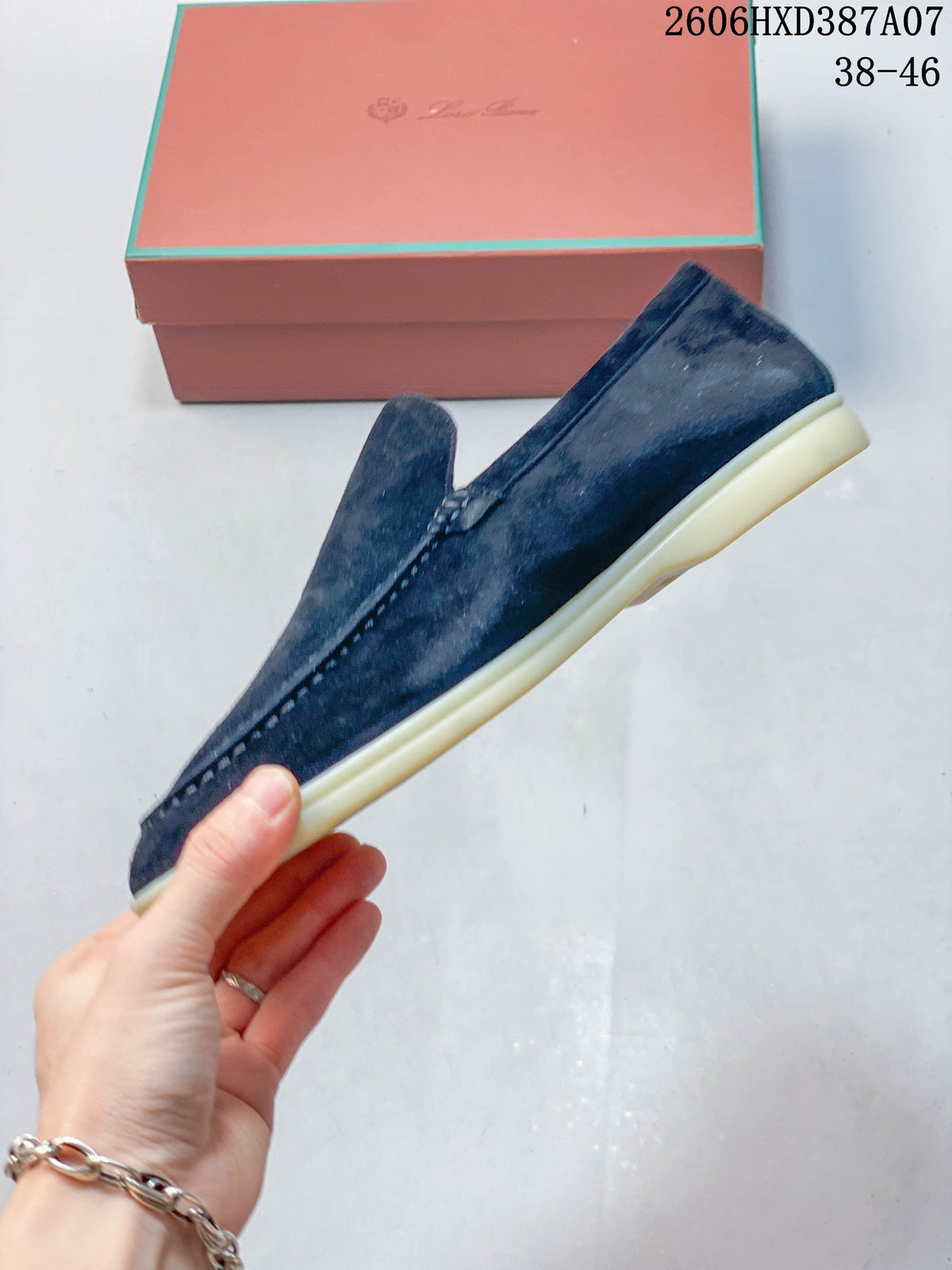 Side profile of a navy slip-on loafer with a light-colored sole