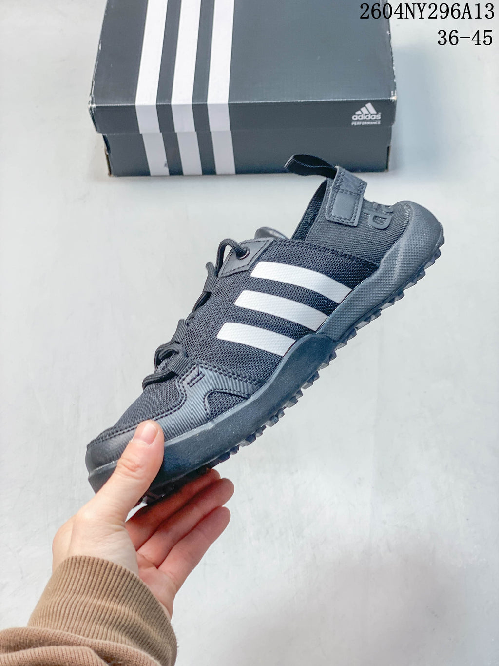 Side view of a dark grey adidas Terrex shoe with white stripes and lace-up fastening