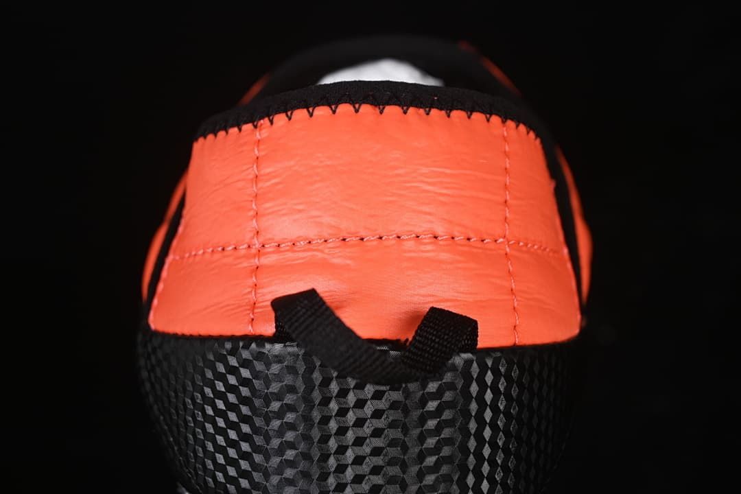 Rear view showing the orange heel panel and black patterned sides