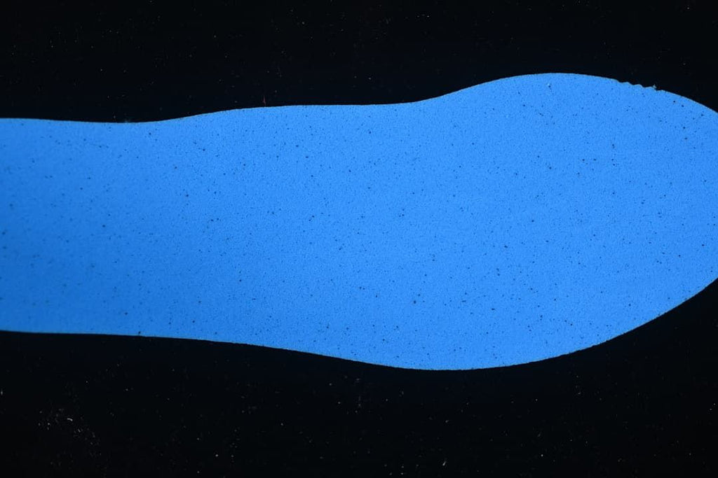 Blue shoe-shaped material sample displayed against a dark background