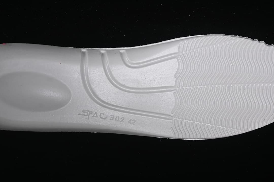 Close-up of the white sneaker outsole and its molded tread.