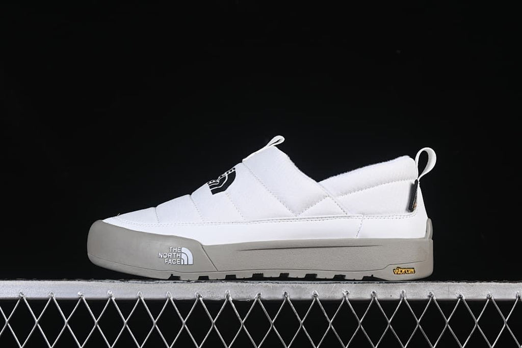 Side view of a white The North Face slip-on shoe with a grey outsole