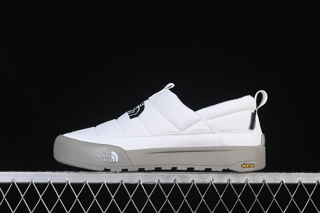 Side view of a white The North Face slip-on shoe with a grey outsole