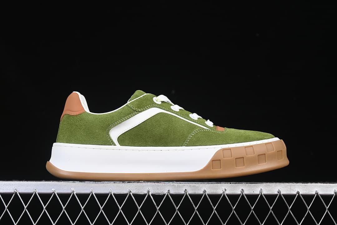 Side profile of the green, white, and tan low-top sneaker