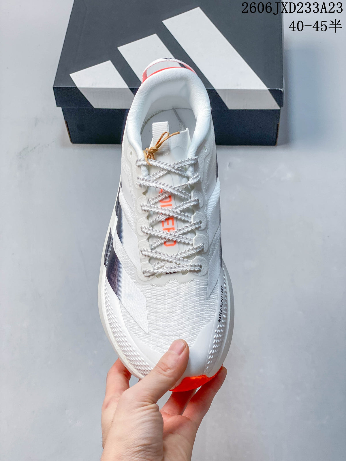 Top view of the white lace-up running shoe with orange tongue details