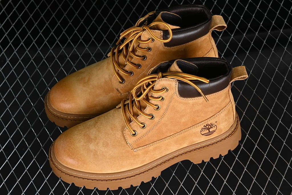 Pair of yellow-brown lace-up boots with dark collars and lugged soles