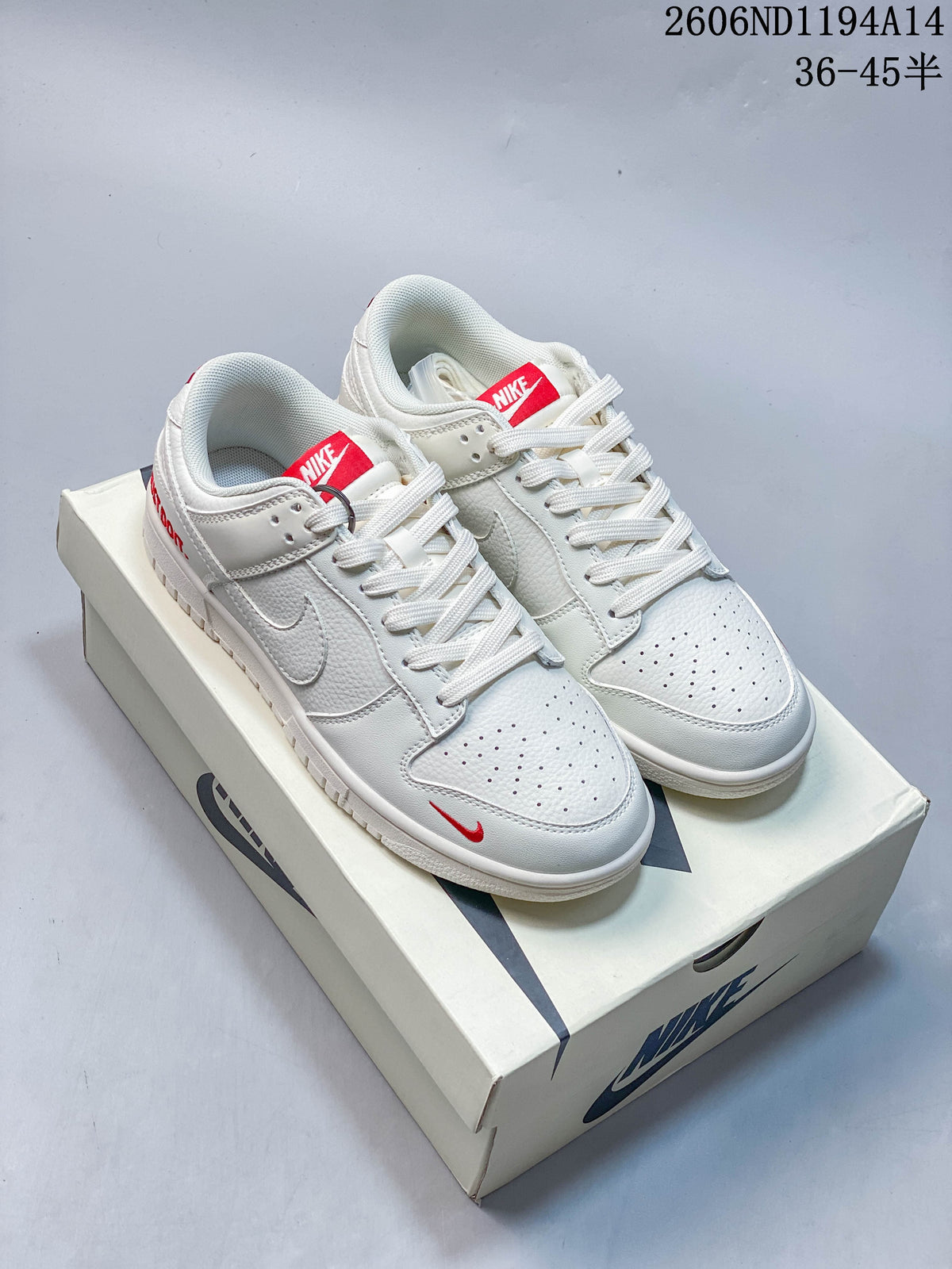 Pair of white low-top sneakers with red tongue labels and small red accents.