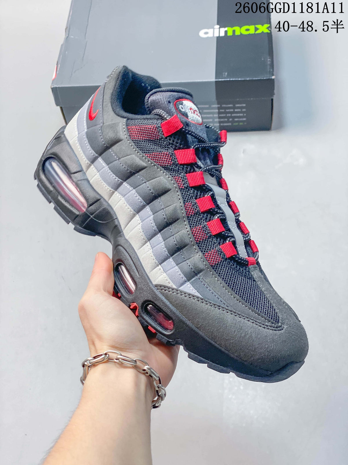 Angled side view highlighting the layered grey panels, red details, and visible sole cushioning