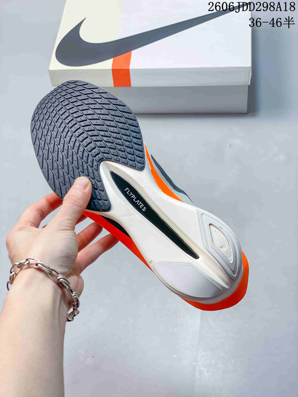 Underside of a Nike Vaporfly shoe showing the patterned dark outsole and orange midsole accents