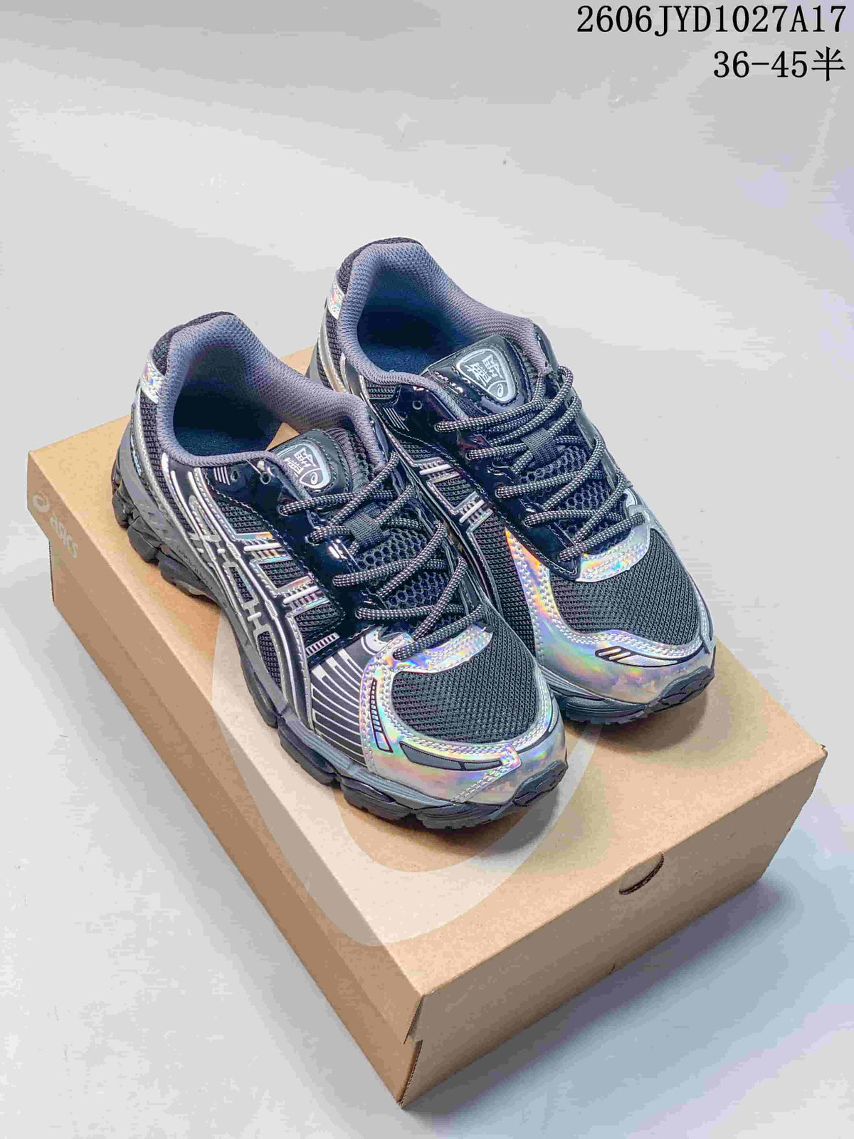 Pair of dark gray Kith x ASICS GEL-KAYANO 12.1 sneakers with iridescent accents, photographed from above