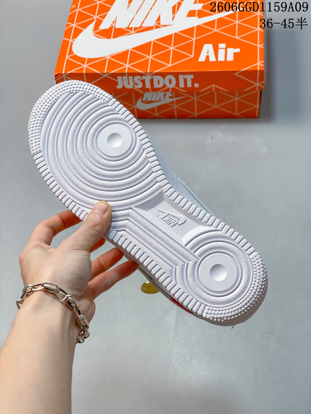 Bottom view of a white sneaker showing its patterned outsole