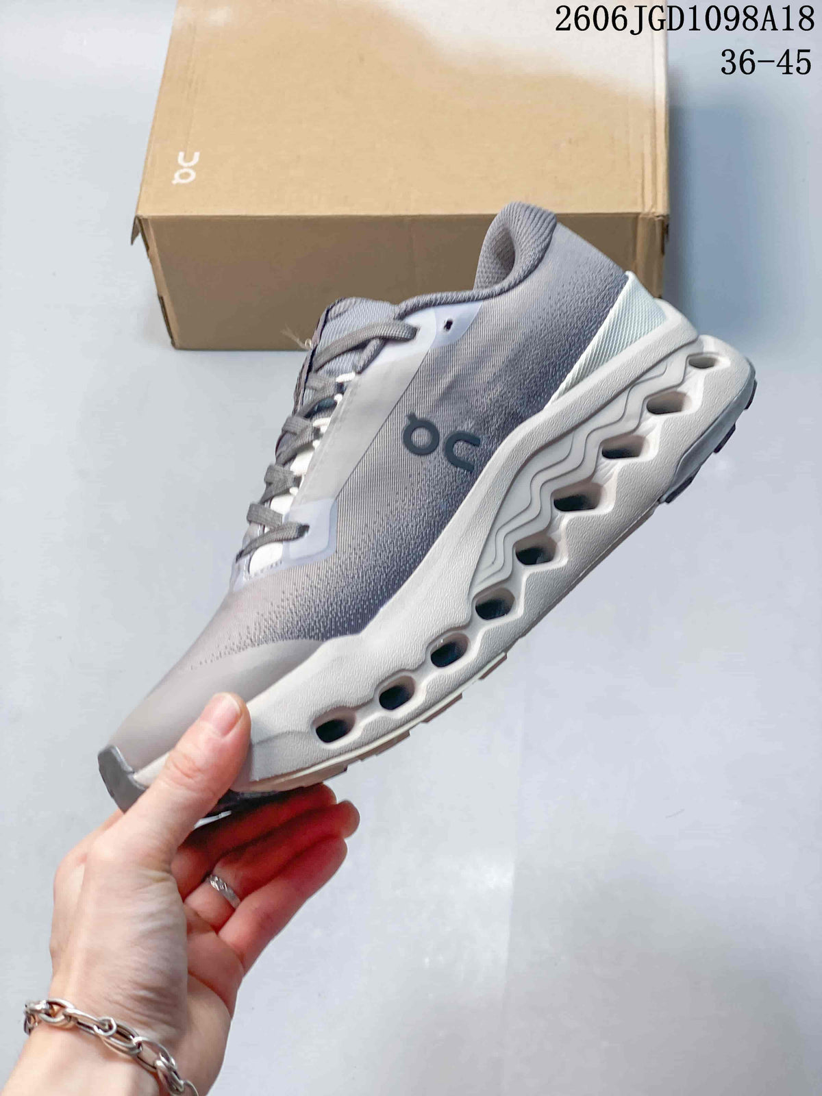 Side view of the gray sneaker showing On branding and the sculpted midsole.
