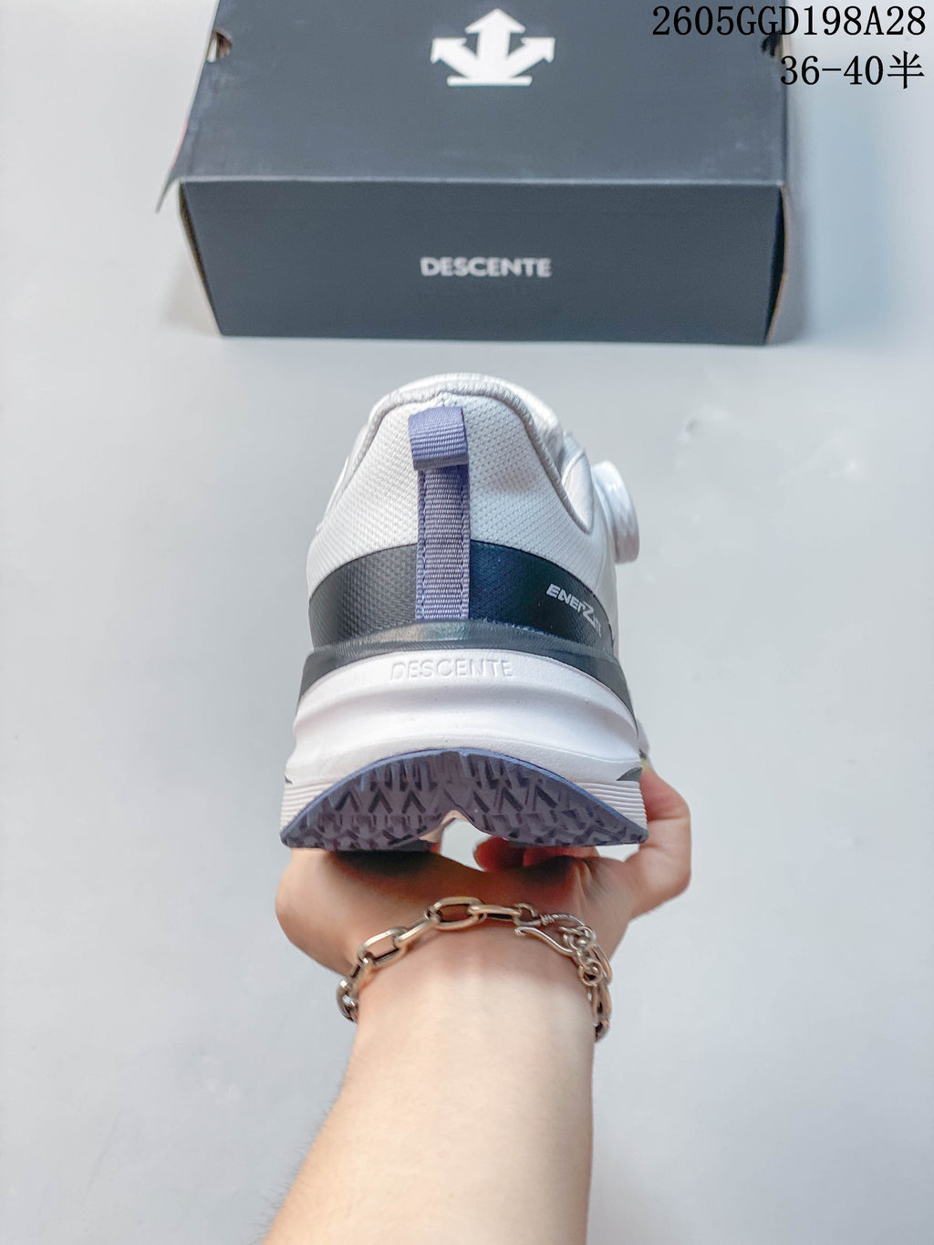 Rear view of the Descente running shoe showing the heel pull tab and layered sole; image overlay shows code 2605GGD198A28 and size range 36–40.5.