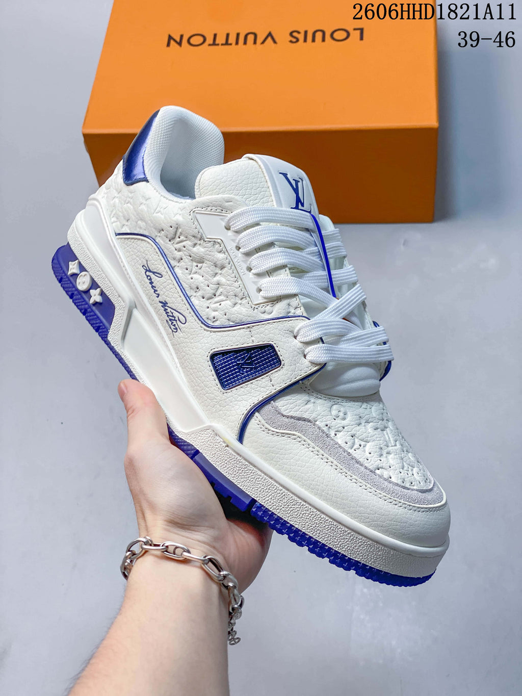 Angled side view of a white and blue LV Trainer sneaker with textured panels.