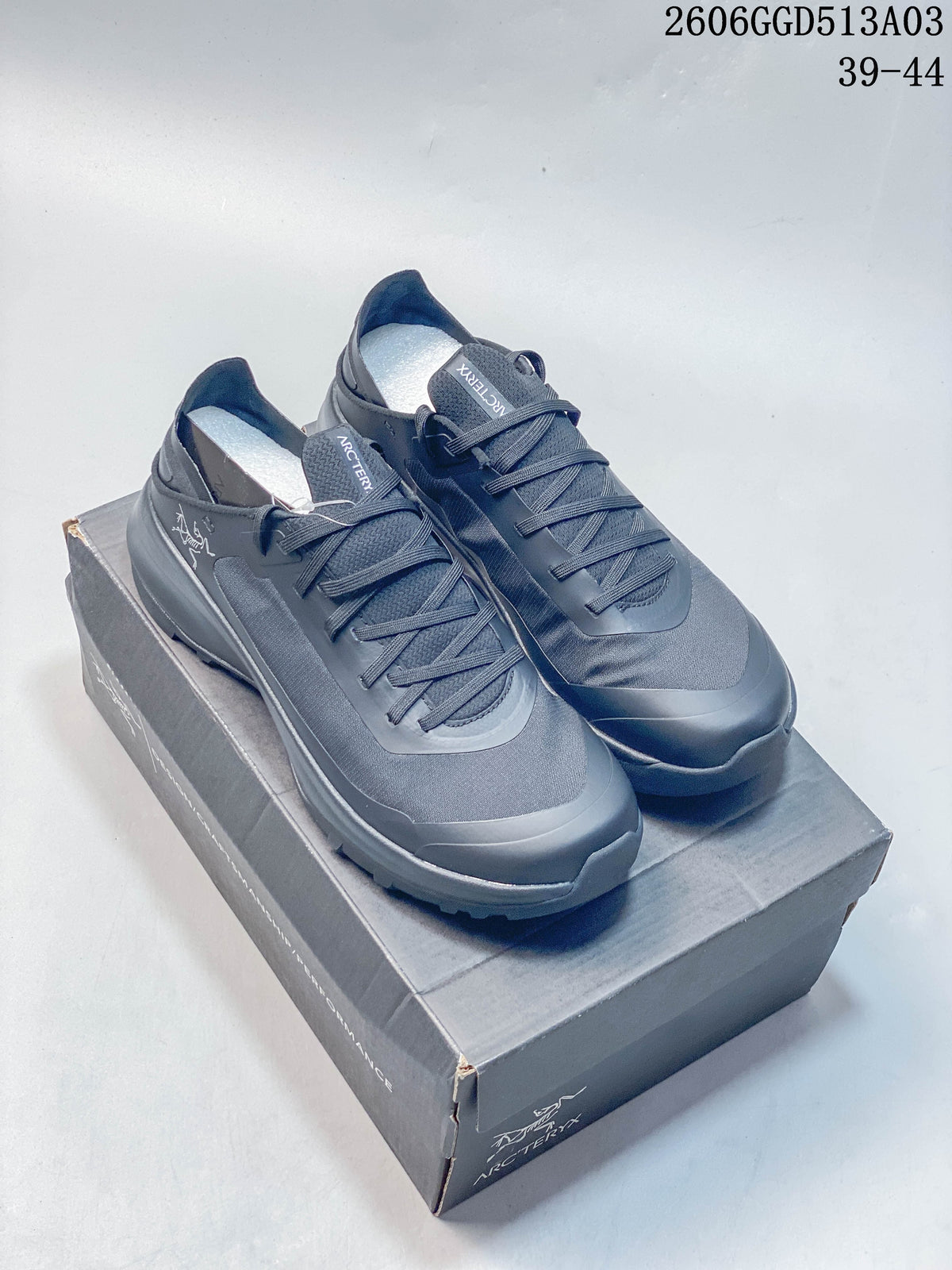 Pair of dark gray Arc'teryx Konseal SL 2 low-cut outdoor shoes on a shoebox