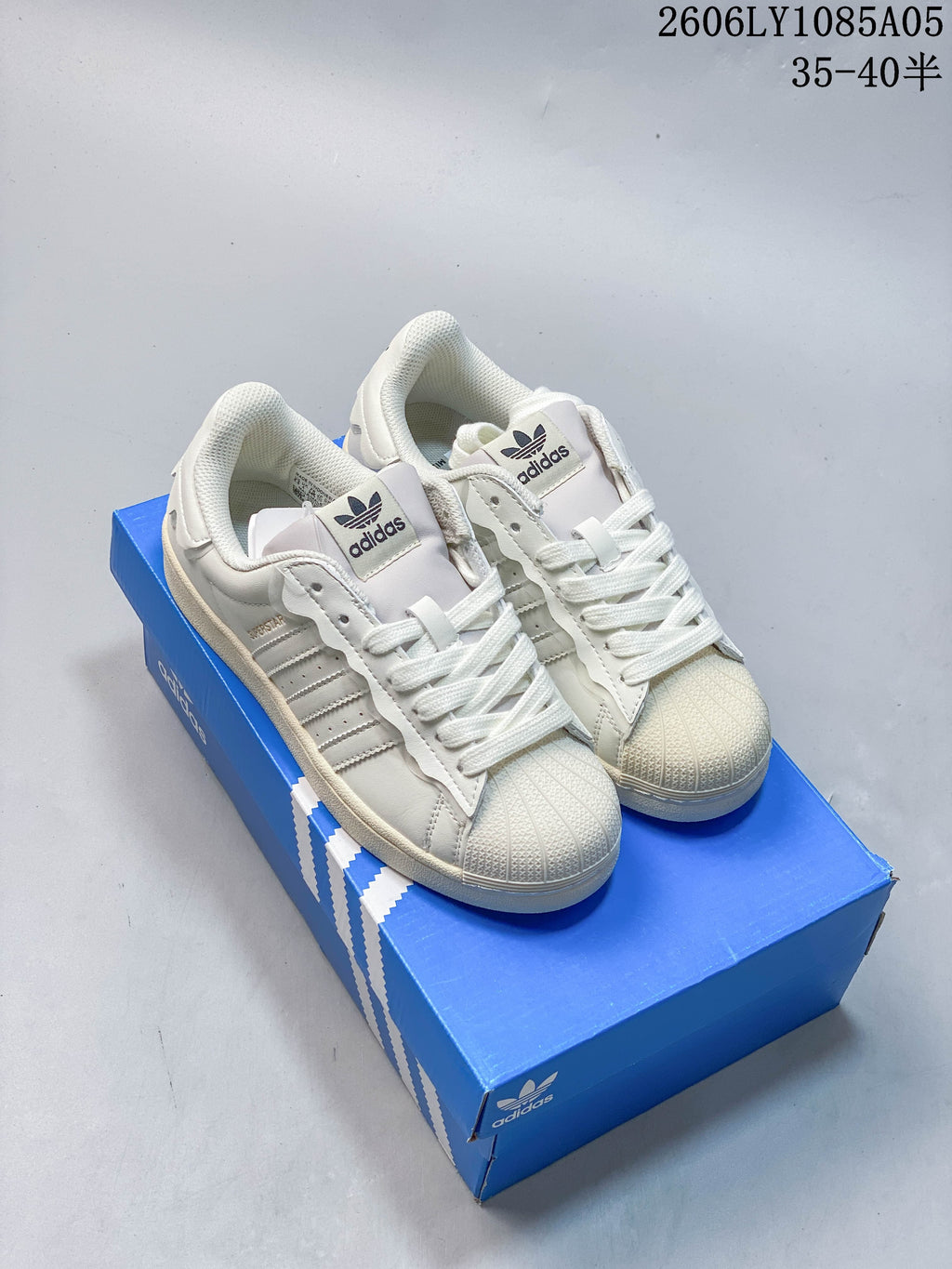 Pair of cream Superstar sneakers with standard white laces