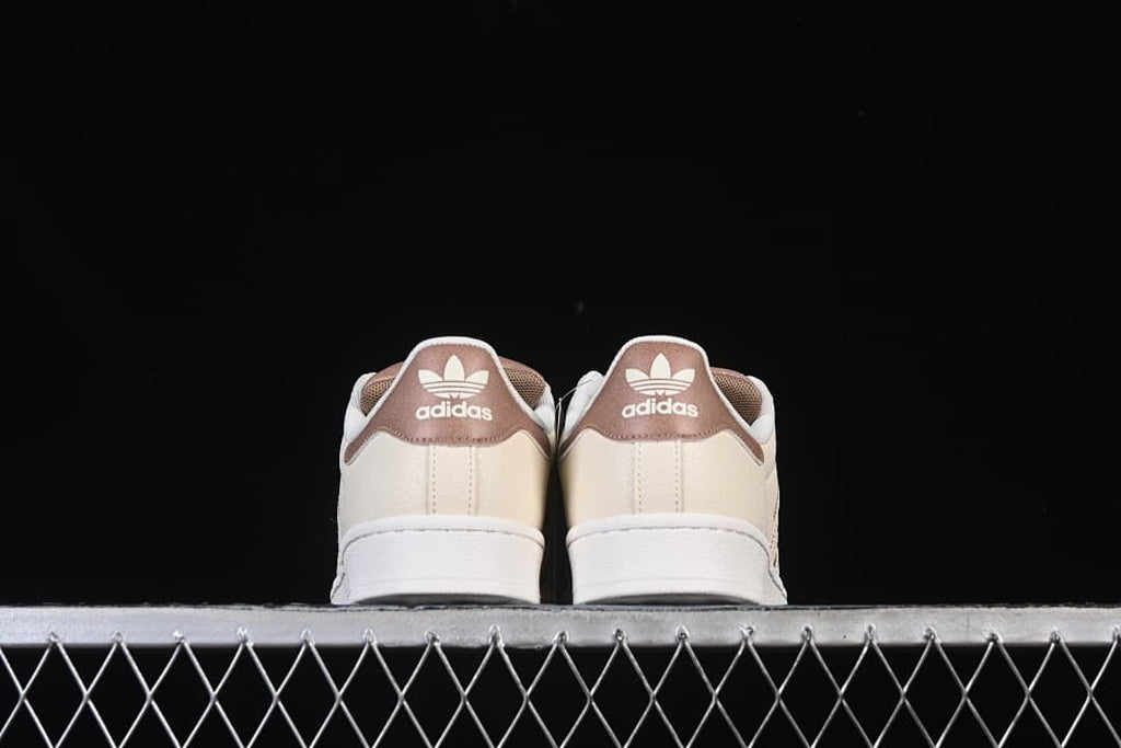 Rear view showing brown heel panels and cream uppers.