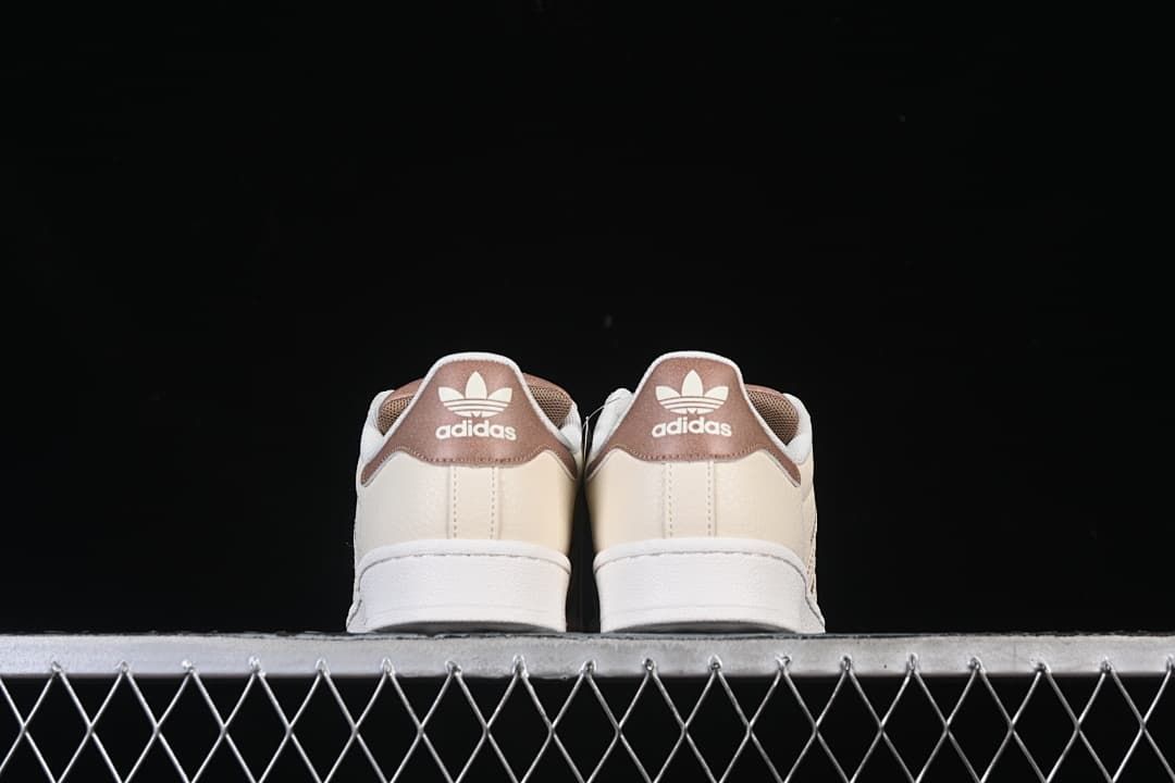 Rear view showing brown heel panels and cream uppers.
