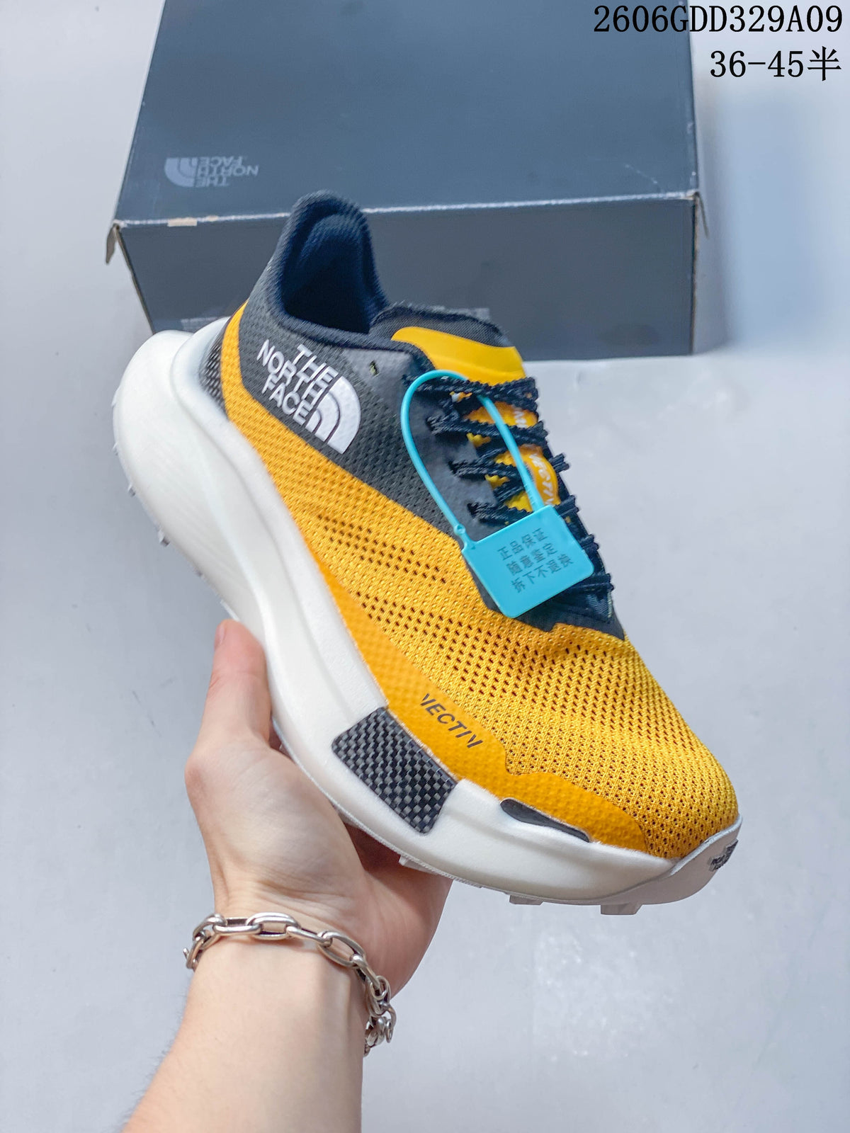 Angled side view of the yellow and dark gray shoe with visible The North Face branding.
