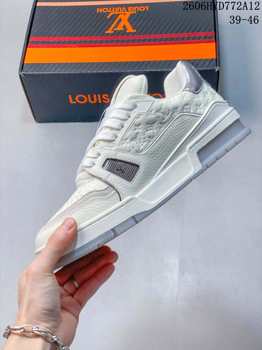 Side profile of a white low-top sneaker with textured panels and silver-tone trim.