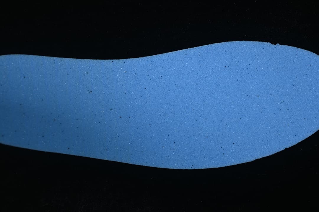 Blue shoe insole shown against a dark background