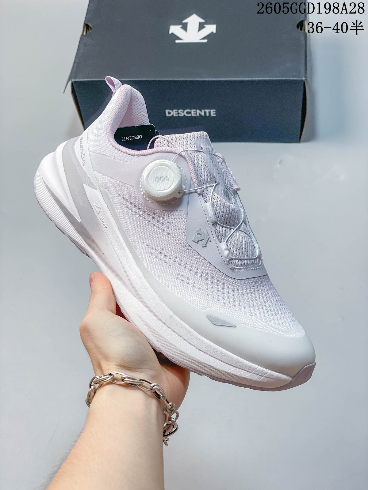 Side view of a pale knit DESCENTE running shoe with a BOA dial closure.