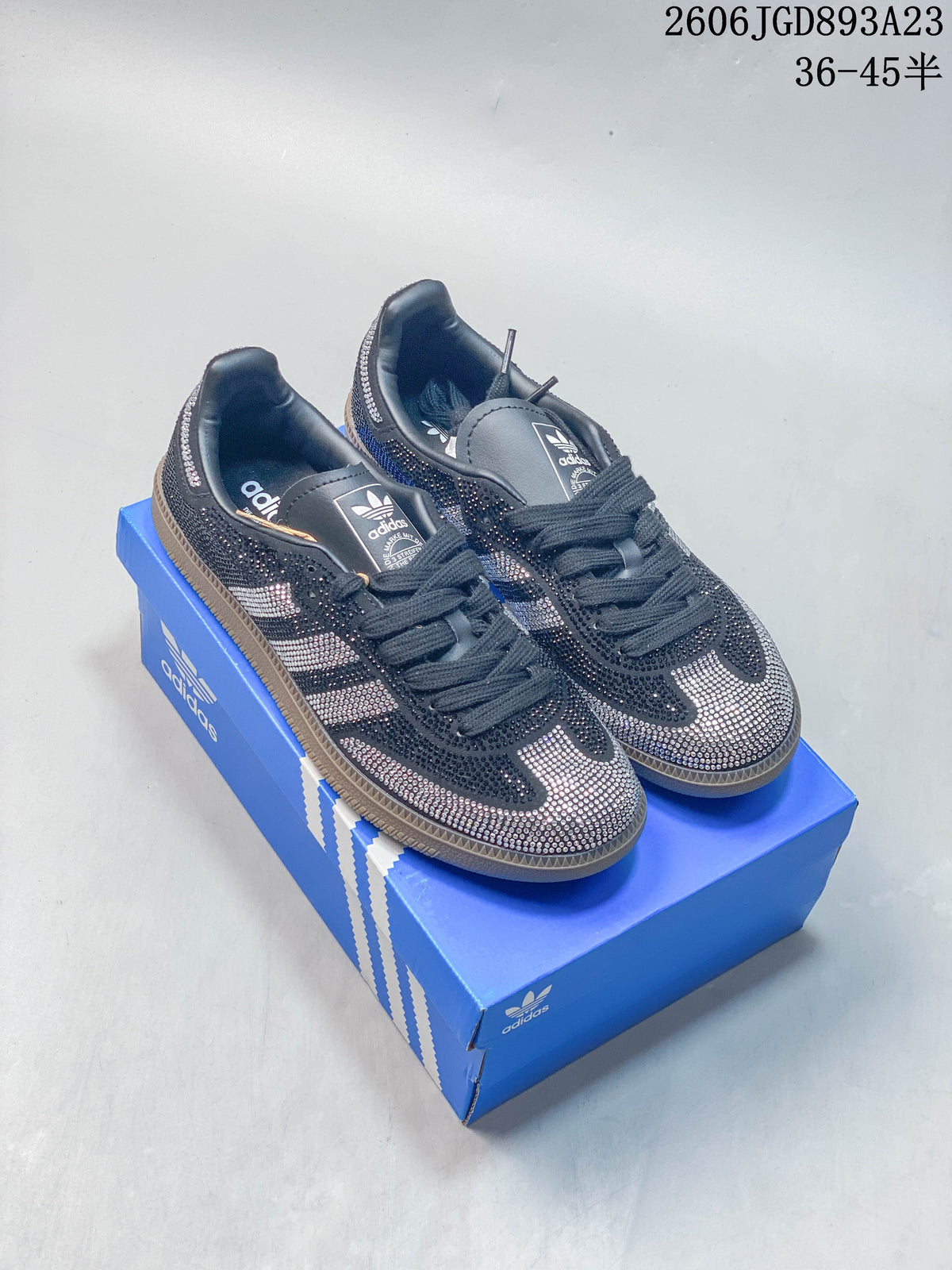 Pair of embellished dark Adidas Handball Spezial sneakers on a blue shoebox