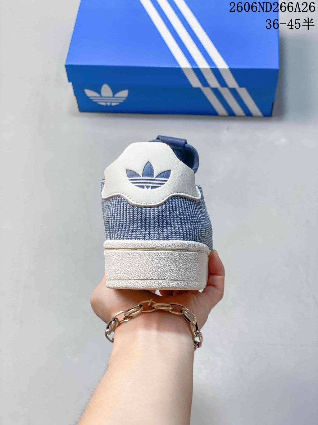 Rear view of a blue sneaker with a white heel tab and white sole.