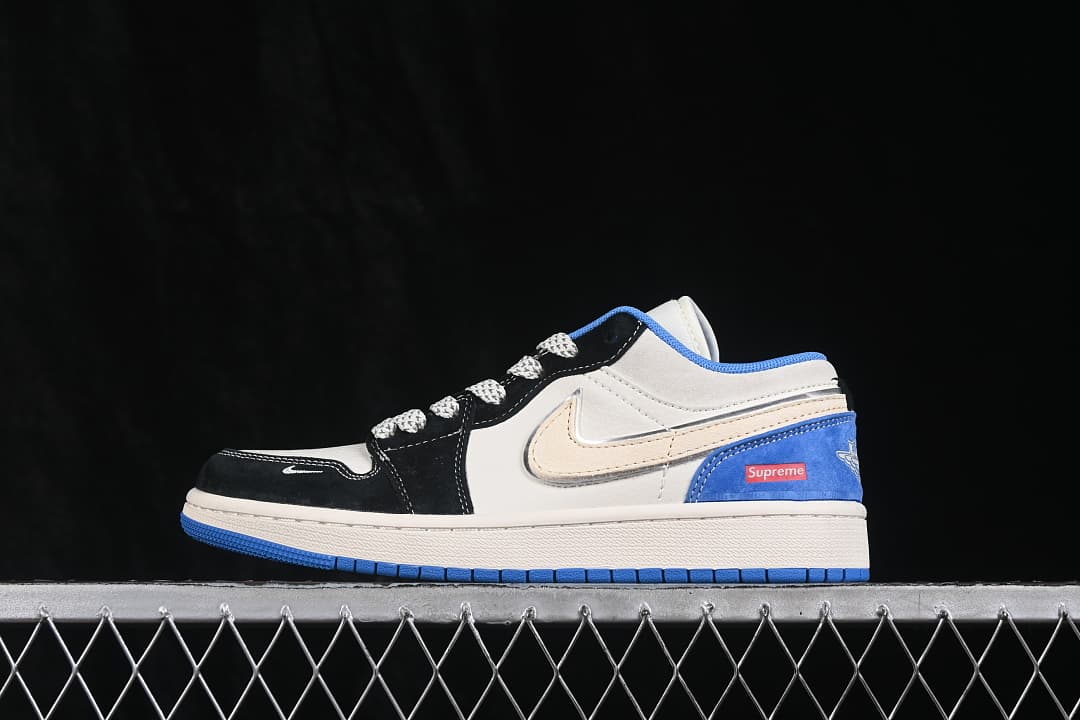 Side view of a white, black, and blue Air Jordan 1 Low sneaker with visible Supreme heel branding.