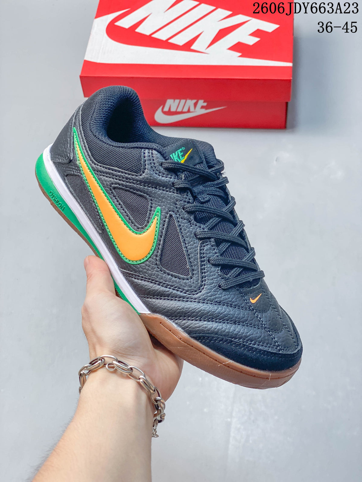 Close-up side view of a dark Nike sneaker with orange and green accents