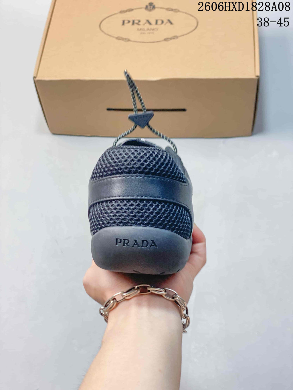 Rear view of a dark blue mesh sneaker with a branded heel and shoebox.