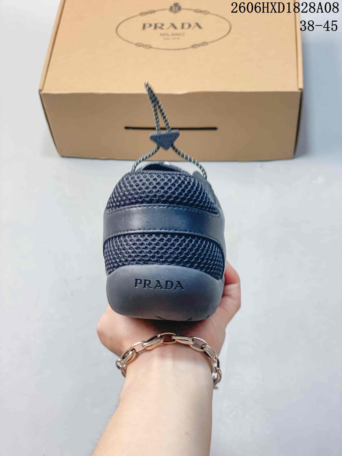Rear view of a dark blue mesh sneaker with a branded heel and shoebox.