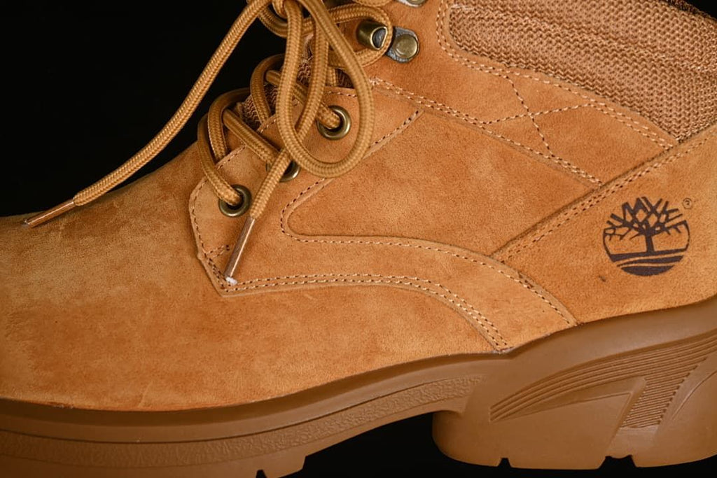 Close-up of the boot's side panels, logo, laces, and metal eyelets