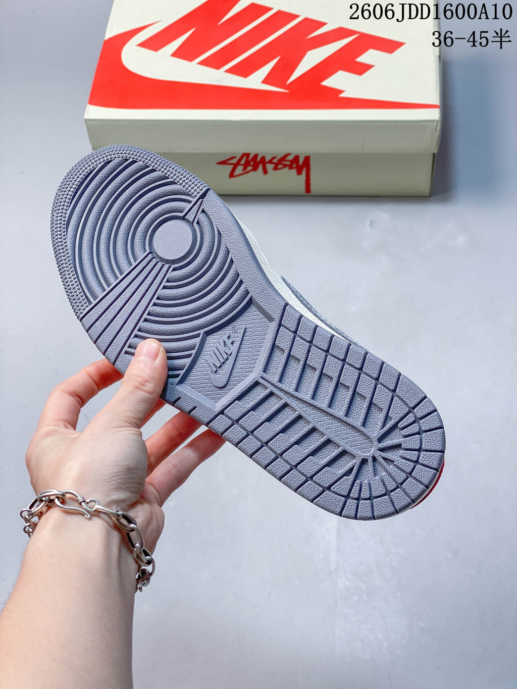 Close-up of the grey patterned outsole and shoebox.