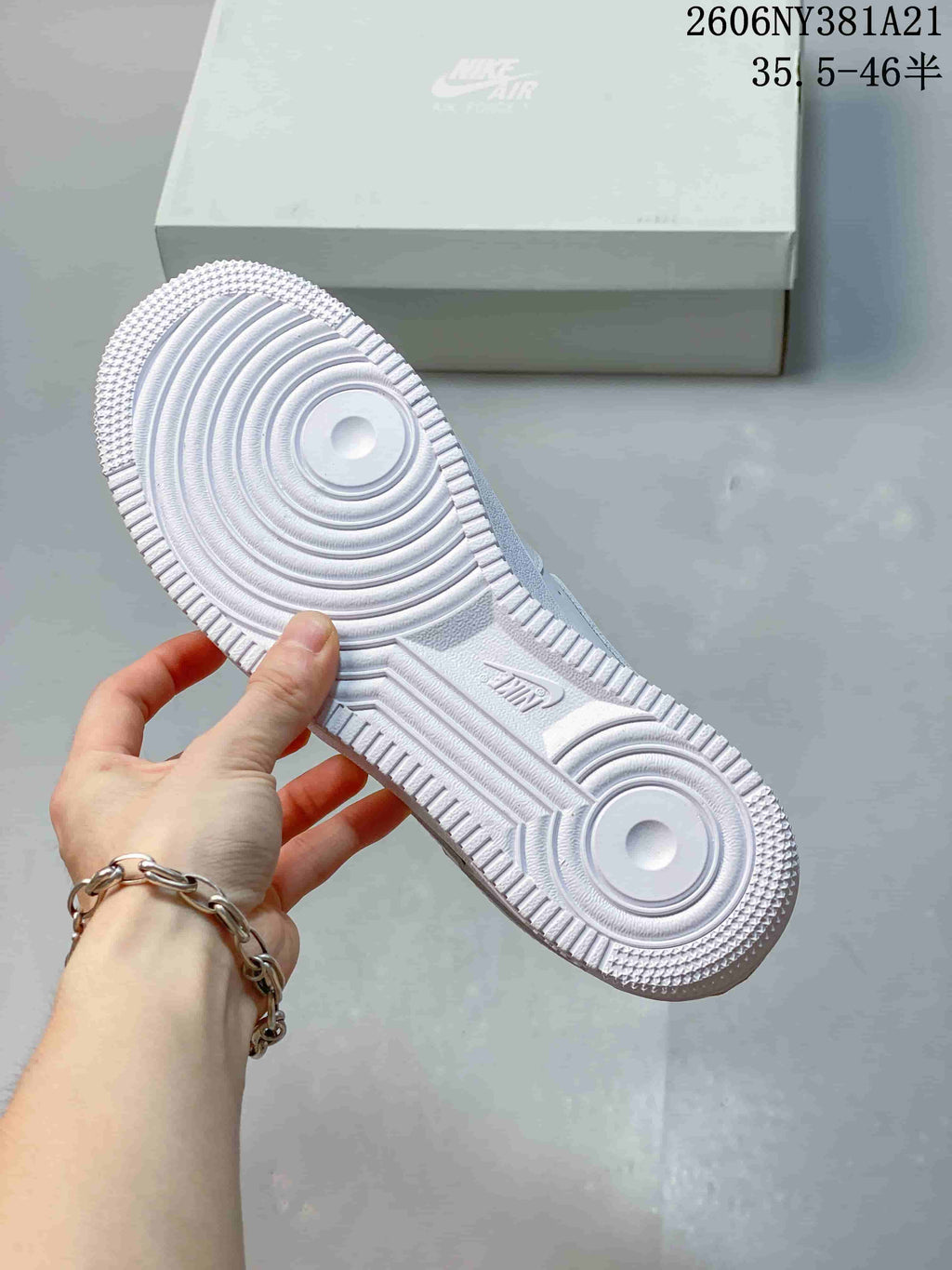 Underside of a white sneaker showing the circular tread pattern