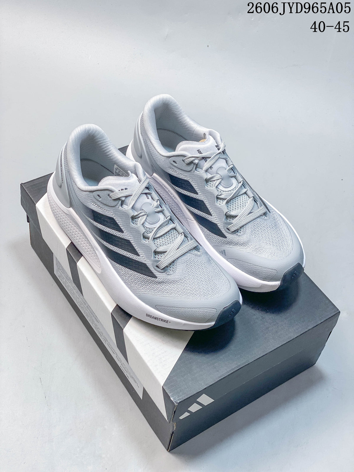 Light gray Adidas Cushionnova running shoes with dark stripes displayed on a shoebox.