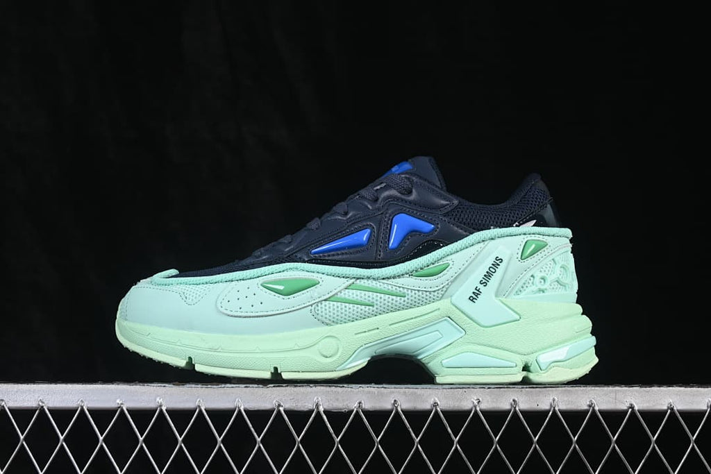Side view of navy and mint Raf Simons Pharaxus low-top sneakers with blue and green accents