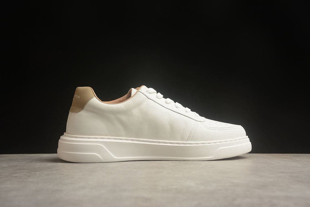 Side profile of the cream low-top sneaker without a visible side logo