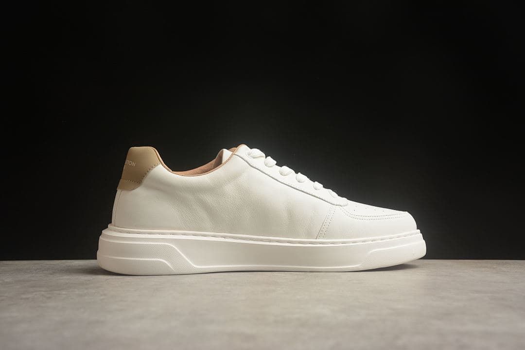 Side profile of the cream low-top sneaker without a visible side logo