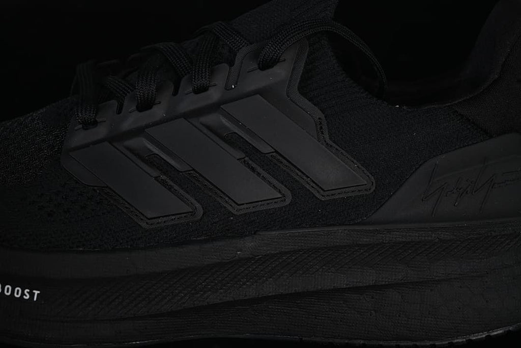 Close-up of the side stripes and sole on the black shoe.
