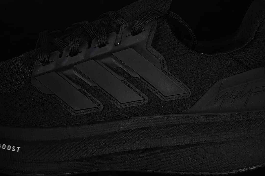 Close-up of the side stripes and sole on the black shoe.
