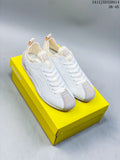 Pair of white and gray Onitsuka Tiger SCLAW low-top sneakers on a yellow shoe box