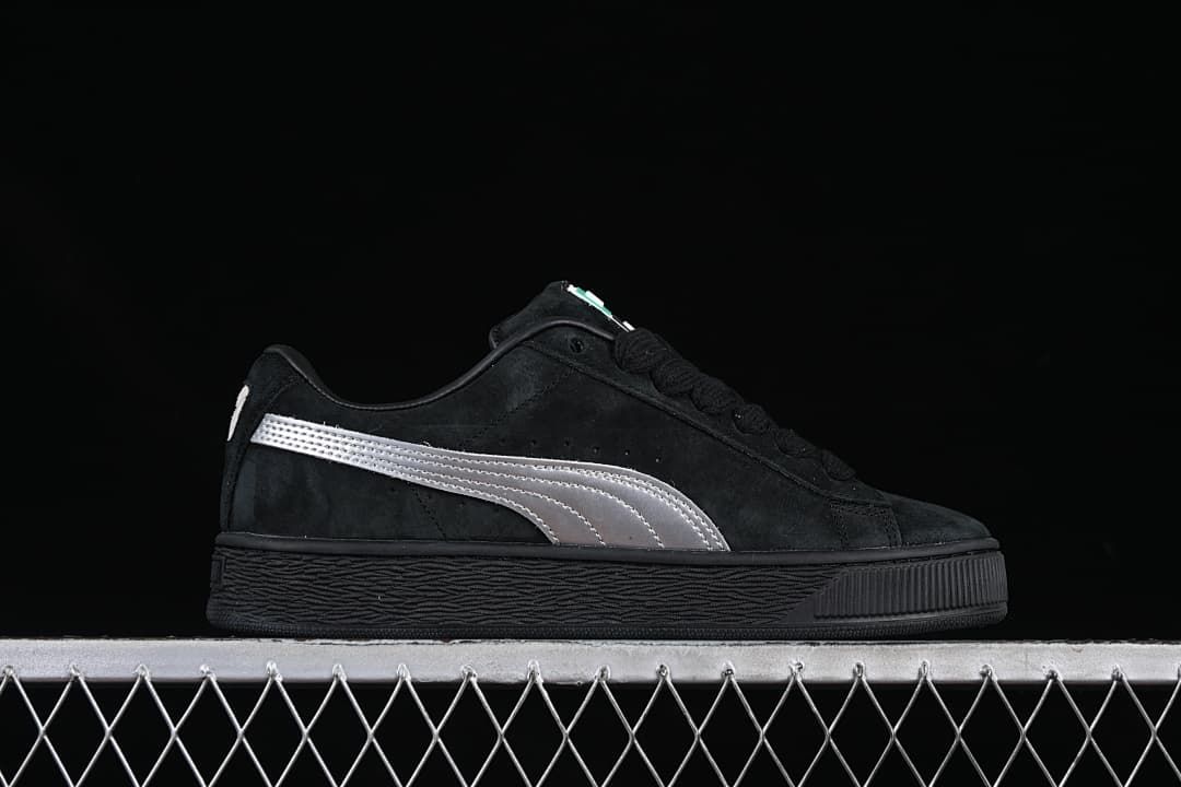 Side profile of a black sneaker with a silver stripe and textured sole.