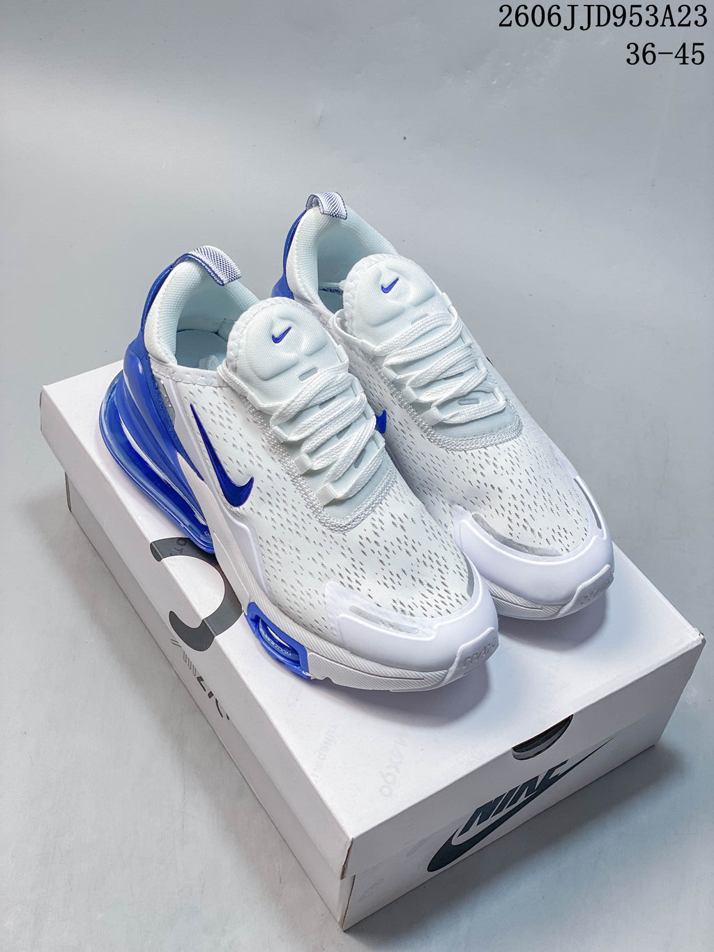 White Nike Air Max 270 sneakers with blue accents, shown on a box.