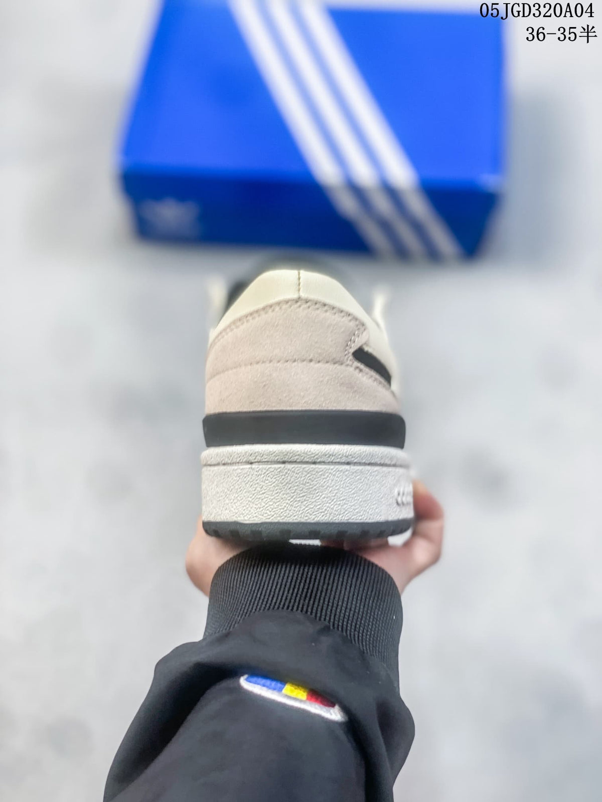 Rear view showing the heel panel and contrasting sole of a cream and black sneaker.